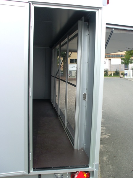 Humbaur HKN 305020-20S mit Einstiegstüre hinten und Verkaufsklappe mit 4-flügeliger Schiebetür aus Polycarbonat, zusätzlich je Ecke eine Teleskopkurbelstütze